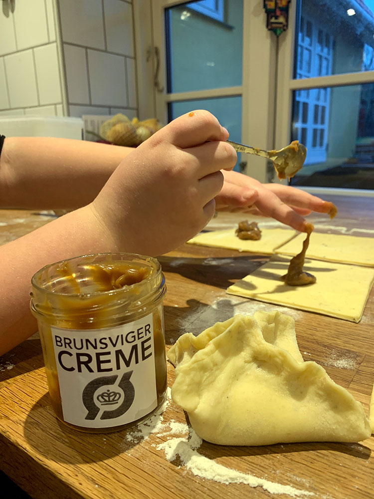 Tilsæt brunsvigercreme og fold hjørnerne på fastelavnsbollerne